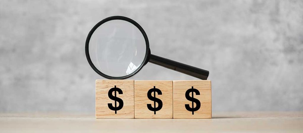 American Dollar symbol block with hand holding glass magnifying. Money, cash, currency and investment concept.